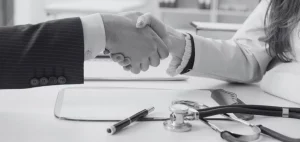 Handschlag zwischen Klinikleitung und Ärztin symbolisiert die Vereinbarung zum optimierten Skill Grade Mix im Krankenhaus